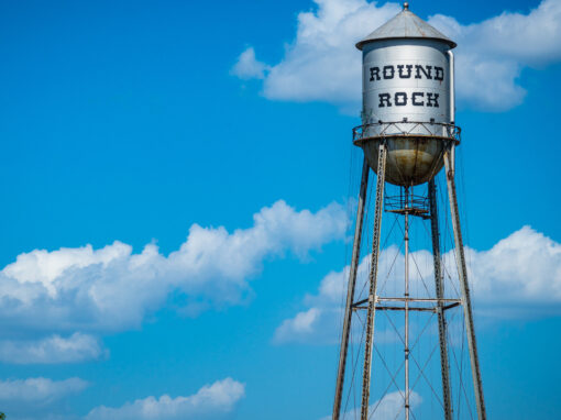Round Rock, Texas water tower against a blue sky backdrop.