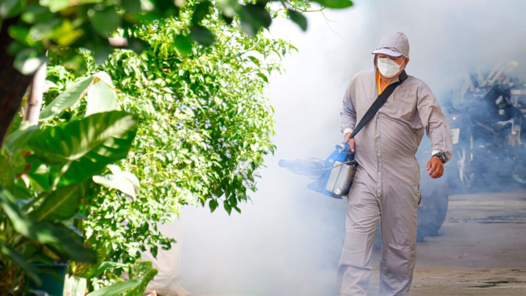 worker spraying toxic chemicals to eliminate mosquitoes
